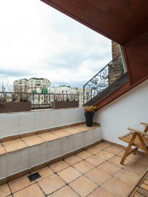 Terrace with armchair on tiled floor in city