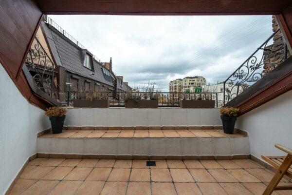 Veranda with potted plants under cloudy sky